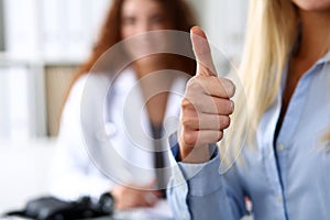 Hand of business woman showing OK sign with thumb up