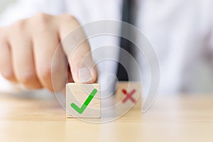 Hand of a businessman chooses checkmark and x sign symbol photo