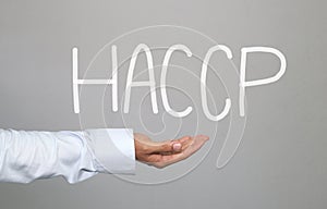 Hand of businessman and hand drawn text HACCP system.