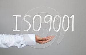 Hand of businessman and hand drawn text ISO9001 system.