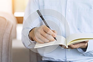 Hand of businessman holding pen and notebook, Writing something idea on note or check list