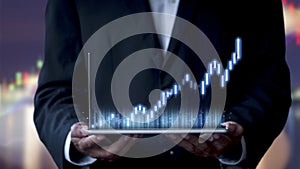 Hand of businessman holding tablet analysis stock market graph growth and increase of chart positive indicators. Hand holding