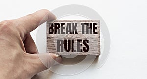 Hand of a businessman holding wooden blocks. Conceptual image. Text BREAK THE RULEs concept business succeed