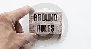 Hand of a businessman holding wooden blocks. Conceptual image. Text GROUND RULES concept business succeed