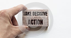 Hand of a businessman holding wooden blocks. Conceptual image. Text TAKE DECISIVE ACTION concept business succeed