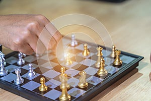 Hand of businessman moving chess figure in competition success play