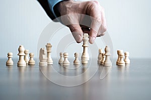 Hand of businessman moving chess figure in competition success play. strategy, management or leadership concept.