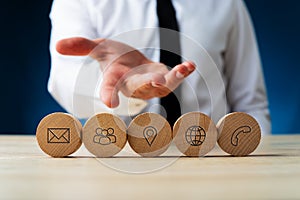 Five wooden circles with contact and information icons on them