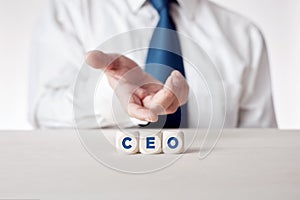 Hand of a businessman presenting the wooden cubes with the word CEO chief executive officer