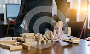 Hand of businessman pulling wood block fail on building