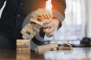 Hand of businessman pulling wood block fail on building