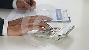 Hand of Businessman Push Calculator to Calculate and Write Report in Truck Shot