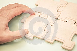 Hand of a businessman putting pieces of jigsaws