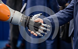 Hand of a businessman shaking hands with a Android robot.