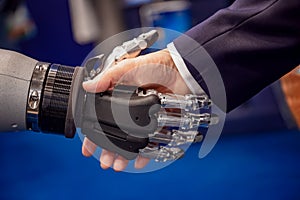 Hand of a businessman shaking hands with a Android robot