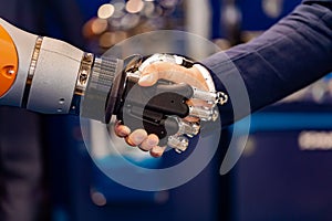 Hand of a businessman shaking hands with a Android robot