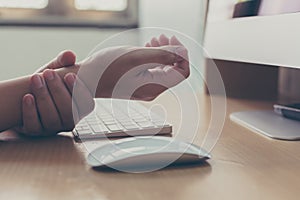 Hand of a businessman with a wrist injury of his own working a computer. Office syndrome concept