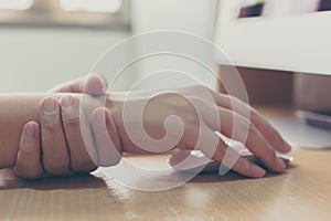 Hand of a businessman with a wrist injury of his own working a computer. Office syndrome concept