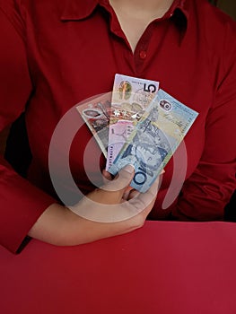 hand of a businesswoman holding australian banknotes