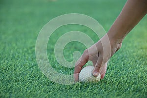 Hand of caddie holding golf ball on green outdoor sport challenge