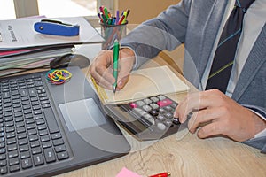 Hand with calculator. Finance and accounting business. Young Businessman Calculating Finance Bills In Office