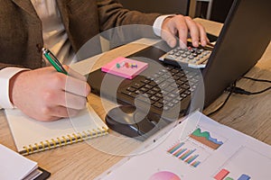 Hand with calculator. Finance and accounting business. Young Businessman Calculating Finance Bills In Office