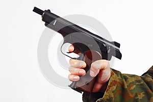 Hand in camouflage uniform with discharged gun on white background