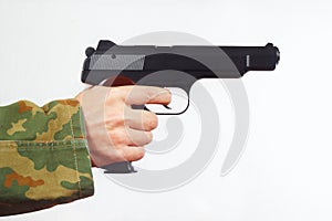 Hand in camouflage uniform with a semi-automatic gun on white background