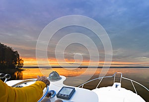 Hand of captain on steering wheel of motor boat in the blue ocean during the fishery day. Success fishing concept. Ocean yacht.