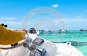 Hand of captain on steering wheel of motor boat in the blue ocean during the fishery day. Success fishing concept. Ocean yacht