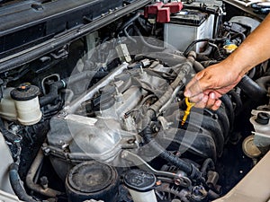 Hand of car mechanic working in auto repair service. He have fix old car engine streaked with dust and oil stains