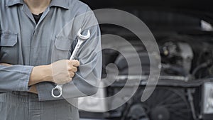 Hand of car mechanic with wrench.