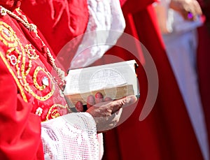 hand of the cardinal reading the book of the bible with the sacred scriptures during the mass