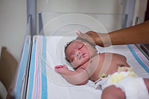 Hand caressing newborn baby