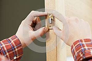 Hand of carpenter at lock installation