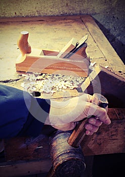 Hand of the carpenter and the workpiece vice with over a plate