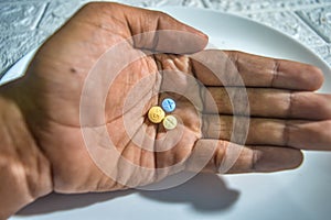 hand carrying three pills for schizophrenic sufferers