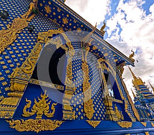 Hand-carved golden ornamentation of Blue Temple or Wat Rong Suea Ten at Chiang Rai Thailand