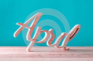 Hand carved wooden letters as April word. 1st day of april concept