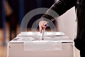 Hand casting a vote into the ballot box photo