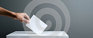 The hand casting a vote into a ballot box symbolizing democracy and civic engagement. AI generated image