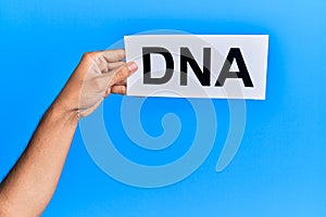 Hand of caucasian man holding paper with dna word over isolated white background