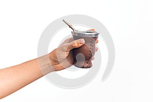 Hand of caucasian young man holding cup of mate infusion beverage over isolated white background