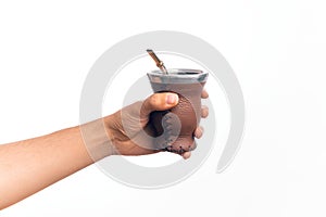 Hand of caucasian young man holding cup of mate infusion beverage over isolated white background