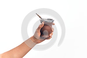 Hand of caucasian young man holding cup of mate infusion beverage over isolated white background