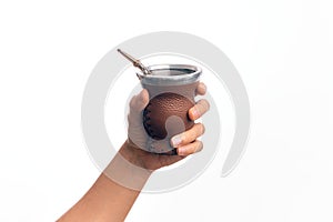 Hand of caucasian young man holding cup of mate infusion beverage over isolated white background