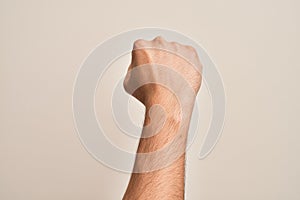 Hand of caucasian young man showing fingers over isolated white background doing protest and revolution gesture, fist expressing