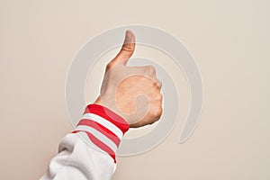 Hand of caucasian young man showing fingers over isolated white background doing successful approval gesture with thumbs up,