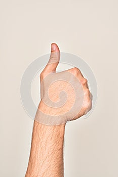 Hand of caucasian young man showing fingers over isolated white background doing successful approval gesture with thumbs up,