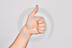 Hand of caucasian young man showing fingers over isolated white background doing successful approval gesture with thumbs up,